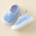 Pair of light blue baby shoes on a beige background