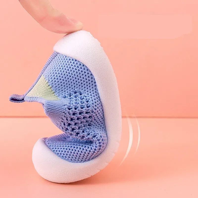  Blue baby shoes featuring soft pliable sole on a pink background