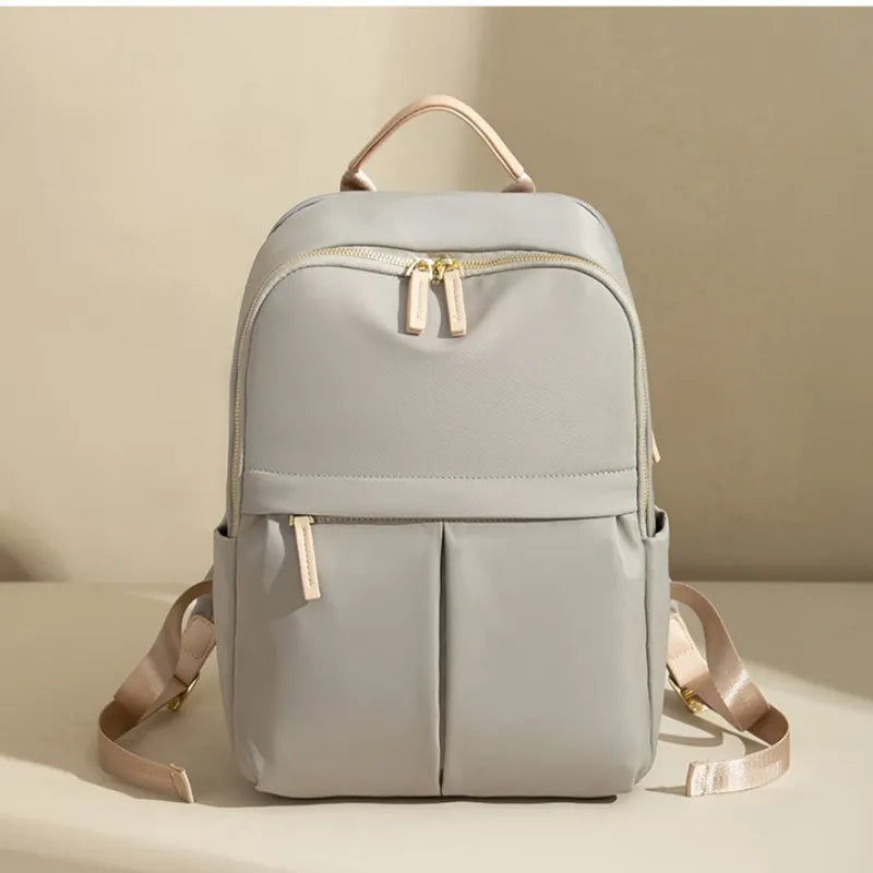 Light gray backpack with beige straps on a beige background