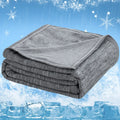 Folded gray cooling blanket against a cold-themed background with ice and snow.