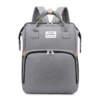Gray multifunction portable diaper backpack with white accents on a white background