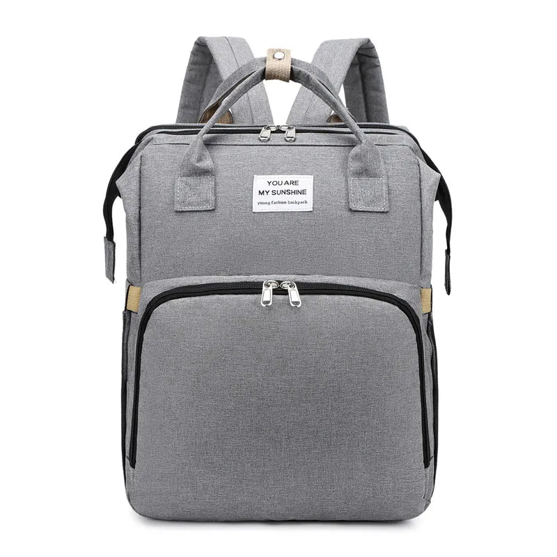 Gray multifunction portable diaper backpack with white accents on a white background