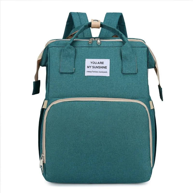 Green multifunction portable diaper backpack with white accents on a white background