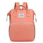 Peach multifunction portable diaper backpack with white accents on a white background