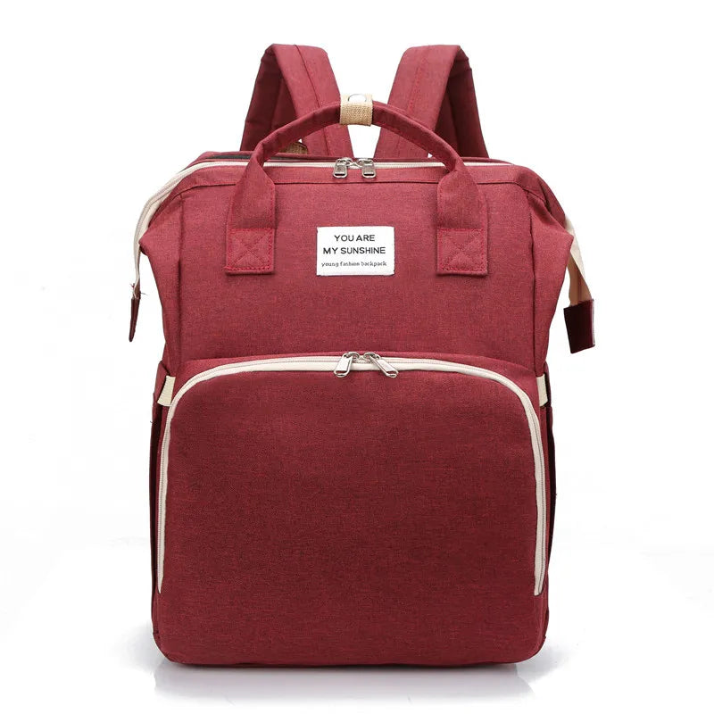 Red multifunction portable diaper backpack with white accents on a white background