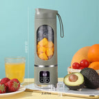 Green portable blender showing dimensions with fruits and a glass of juice on a light blue background
