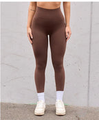 Person wearing brown high waist v-back leggings against a neutral background