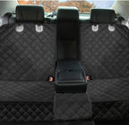 Black quilted car seat cover with a central storage compartment in a vehicle.