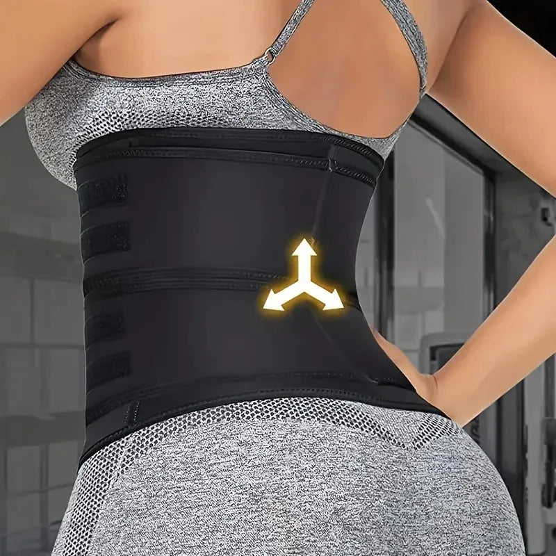 Person wearing a black waist trainer  standing against a blurred indoor background. View of back