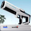 White and black toy water gun with battery and charge chord, palm tree and blue sky in the background